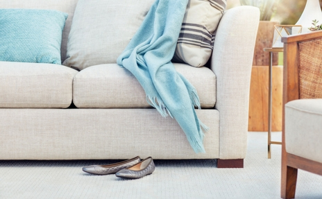 Grey carpet in living room with beige sofa